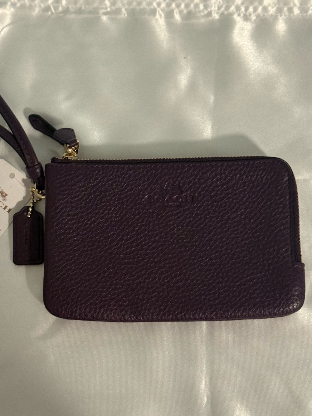 Coach NWT Pebbled Leather Wristlet in Plum w/handtag and two zip compartments.